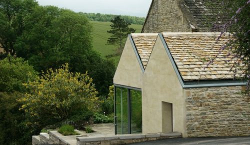 Image of a stone house overlooking picturesque green countryside.